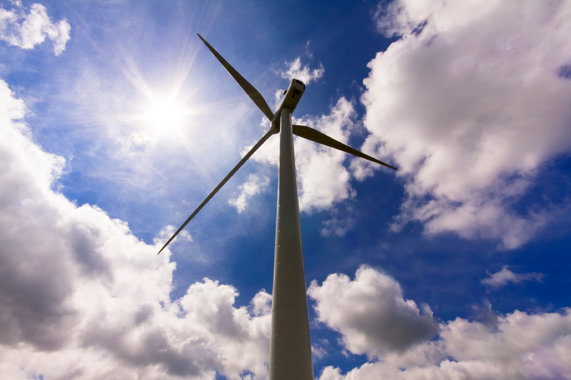 Wind turbine over a cloud filled blue sky Wind turbine over a cloud filled blue sky
