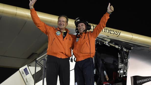Andre Borschberg (L) and Bertrand Piccard celebrate after Solar Impulse 2 touches down in Abu Dhabi