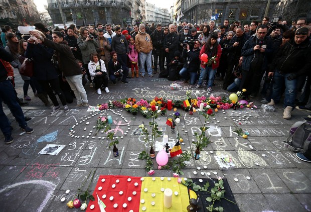 People gather to leave tributes at the Place de la Bourse following today's attacks on March 22, 2016 in Brussels, Belgium. At least 31 people are thought to have been killed after Brussels airport and a Metro station were targeted by explosions. The attacks come just days after a key suspect in the Paris attacks, Salah Abdeslam, was captured in Brussels. (Photo by Carl Court/Getty Images)
