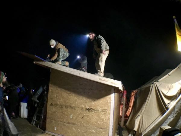 Erecting a shelter at Oceti Sakowin Camp as winter approaches, despite an order to vacate by December 5. (Photo: Jenni Monet)