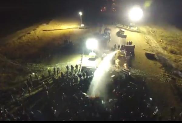 No fire trucks, or fires, in evidence as military vehicles fire water cannons at unarmed protectors in overnight conflict at DAPL. (Photo: Facebook/Dallas Goldtooth)