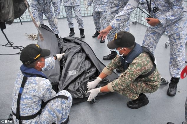 On Tuesday, remains were found in the John McCain; here, Navy sailors cover an unidentified body, believed to be one of those found in the wreckage after it was recovered