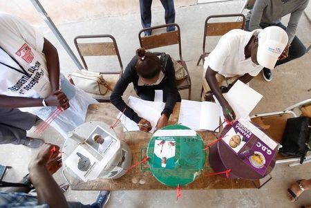 Poll workers register voters during the presidential election in Banjul