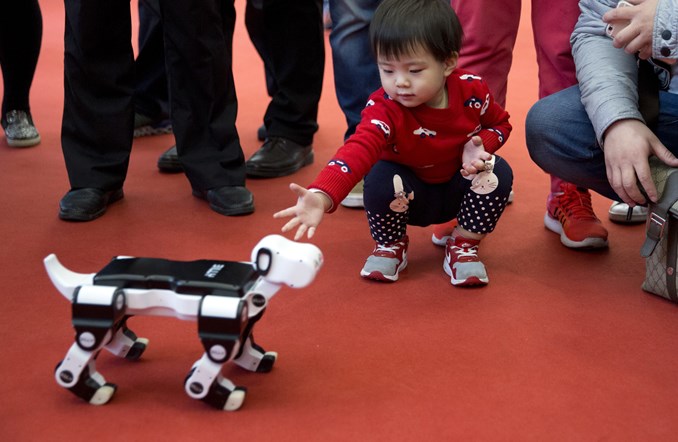 Image::A child reaches out to a robotic dog at the World Robot Conference in Beijing in 2016.|||[object Object]
